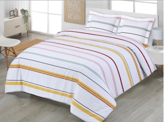 Funda Nórdica Xàbia de Dhestia Home con diseño de rayas multicolor en cama de matrimonio